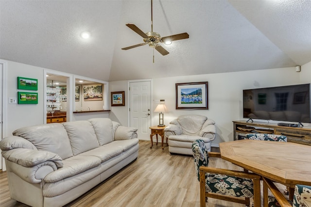 living area featuring light wood finished floors, ceiling fan, and a textured ceiling