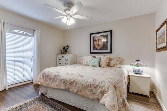 bedroom featuring ceiling fan, wood finished floors, and baseboards