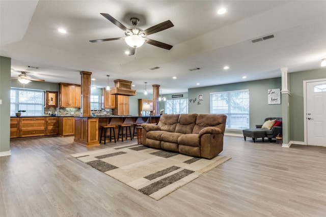 living area featuring recessed lighting, a healthy amount of sunlight, visible vents, and light wood finished floors