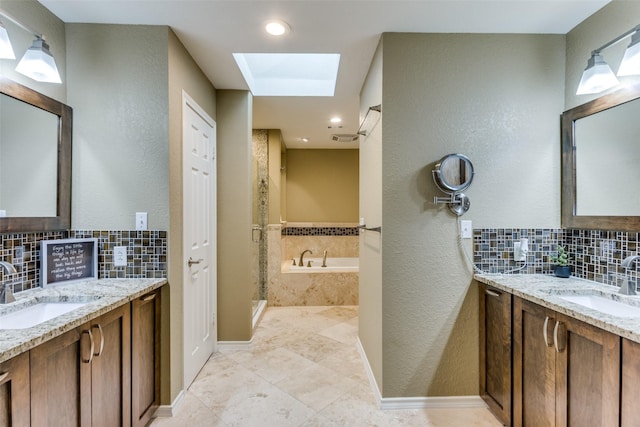 bathroom with a skylight, a sink, and decorative backsplash