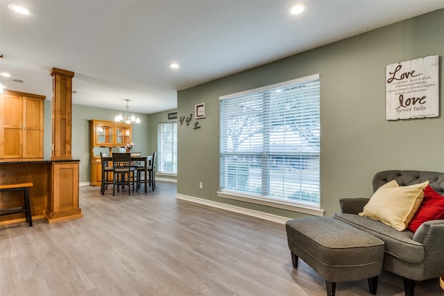 living area featuring light wood-type flooring, decorative columns, baseboards, and recessed lighting