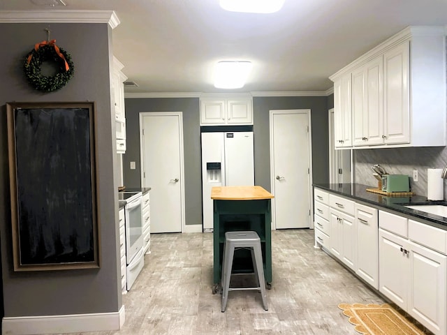 kitchen with wooden counters, white appliances, a kitchen island, and white cabinets