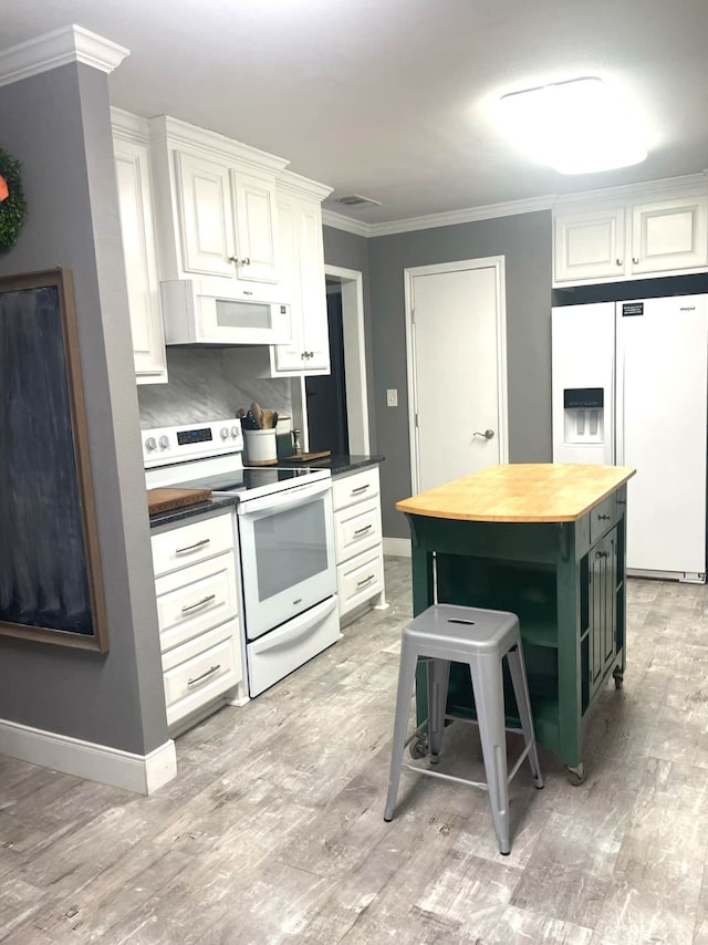 kitchen featuring white appliances, white cabinetry, ornamental molding, light wood-type flooring, and a center island