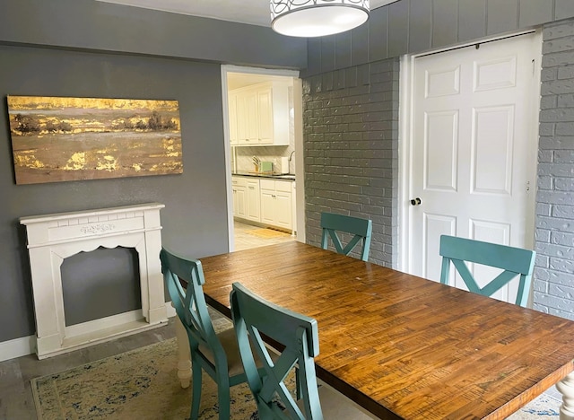 dining room featuring brick wall