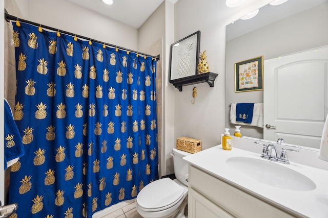 bathroom with toilet, tile patterned flooring, and vanity