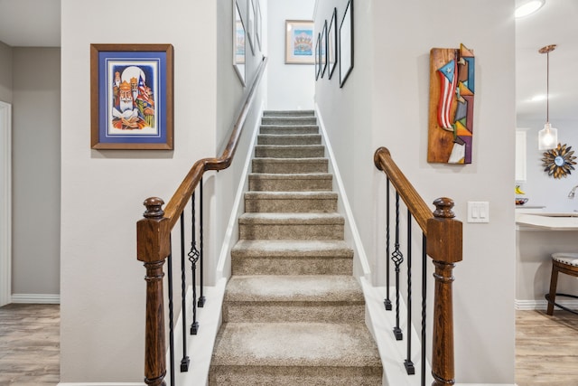 staircase with wood finished floors and baseboards