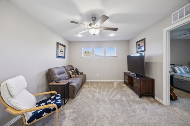 living area with light carpet, baseboards, visible vents, and ceiling fan