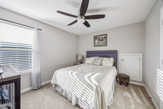 bedroom with light colored carpet, baseboards, and multiple windows