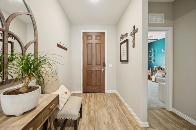 entryway featuring light wood-type flooring, visible vents, and baseboards