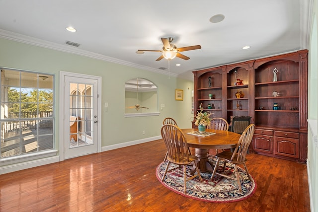 dining area featuring dark wood-style floors, ornamental molding, and visible vents