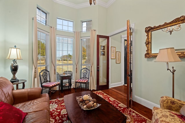 sitting room with ornamental molding, dark wood-style flooring, and baseboards