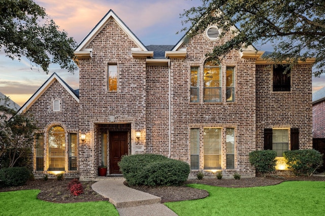 traditional-style house with a front lawn and brick siding