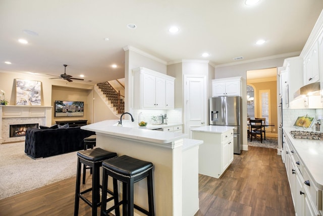 kitchen with white cabinets, appliances with stainless steel finishes, a peninsula, light countertops, and a kitchen bar