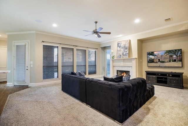 living area featuring dark wood-style flooring, crown molding, recessed lighting, a premium fireplace, and baseboards