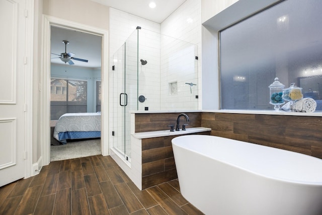 bathroom with a stall shower, ensuite bath, wood tiled floor, a freestanding tub, and tile walls