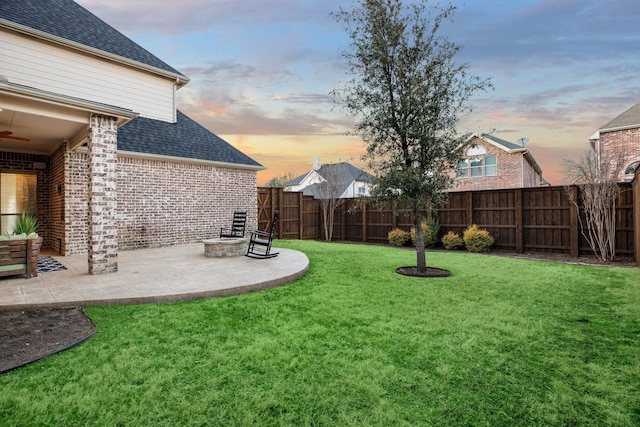 yard at dusk featuring a patio and a fenced backyard