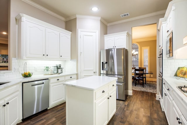 kitchen featuring dark wood-type flooring, a kitchen island, visible vents, white cabinets, and appliances with stainless steel finishes