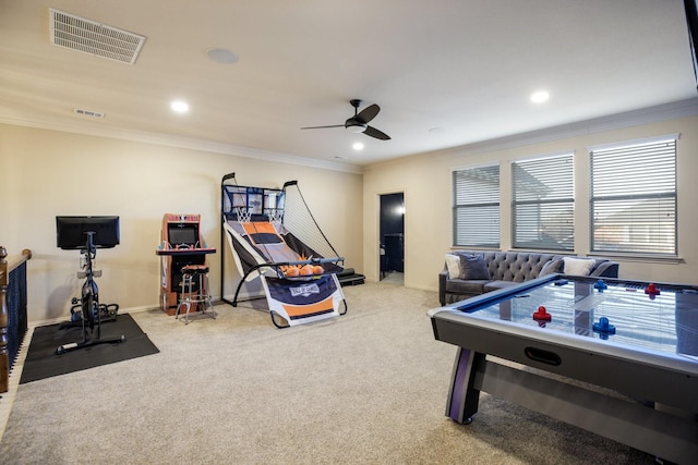 rec room with light carpet, ornamental molding, visible vents, and a ceiling fan