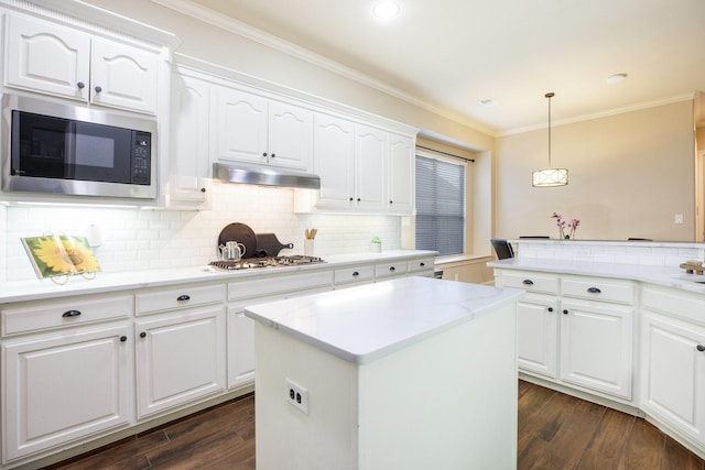 kitchen with white cabinetry, decorative light fixtures, and built in microwave