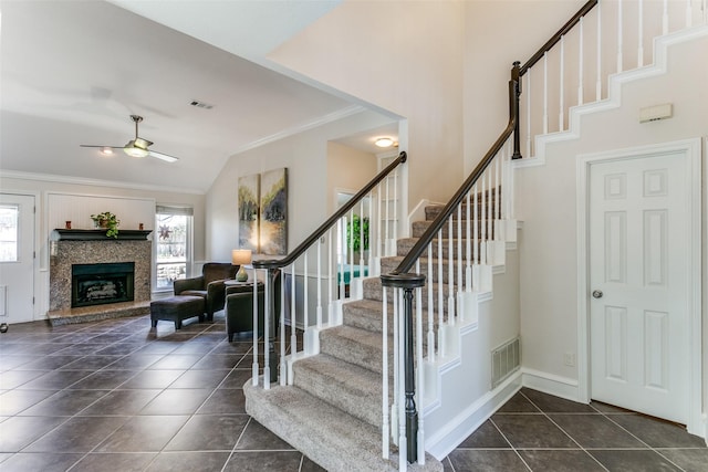 staircase featuring tile patterned flooring, a healthy amount of sunlight, visible vents, and ornamental molding