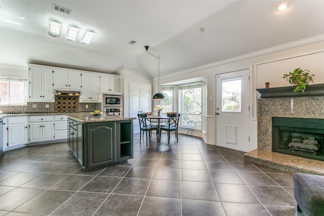 kitchen featuring visible vents, dark tile patterned floors, white cabinetry, stainless steel appliances, and lofted ceiling