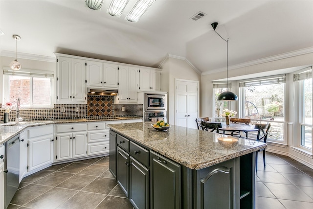 kitchen featuring under cabinet range hood, appliances with stainless steel finishes, white cabinetry, and a sink