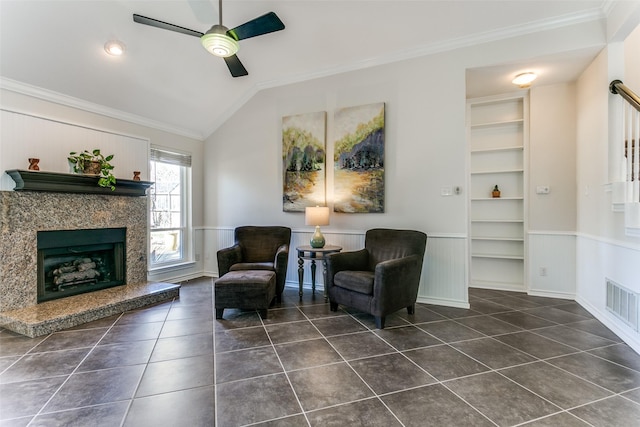 living area with built in features, visible vents, wainscoting, and crown molding