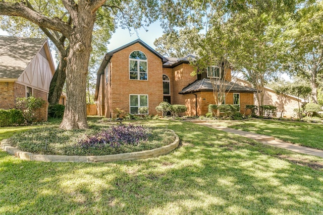 traditional-style house featuring brick siding and a front lawn