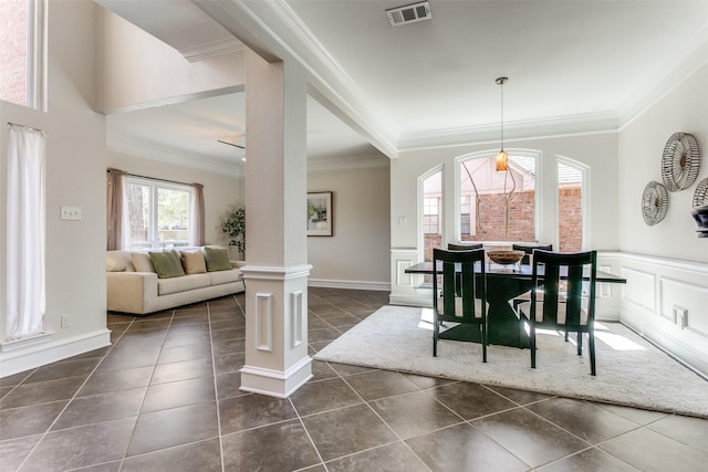 dining room featuring visible vents, dark tile patterned floors, ornamental molding, wainscoting, and ornate columns