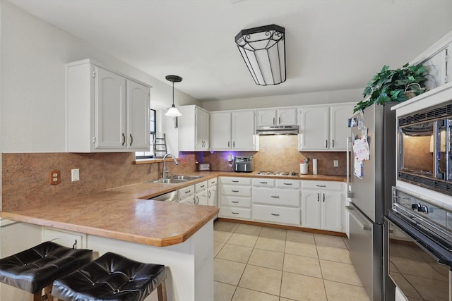 kitchen featuring pendant lighting, white cabinets, a peninsula, and black appliances