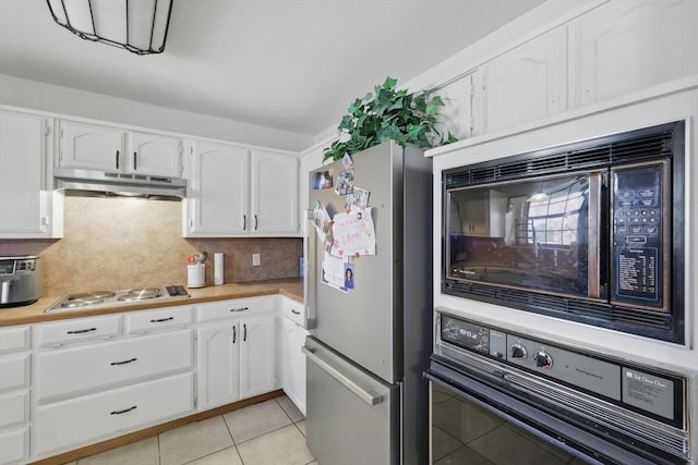 kitchen with wall oven, white cabinets, freestanding refrigerator, under cabinet range hood, and black microwave