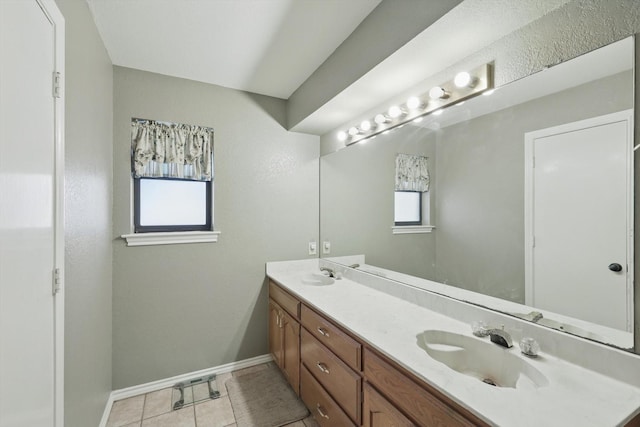 full bath featuring double vanity, baseboards, a sink, and tile patterned floors