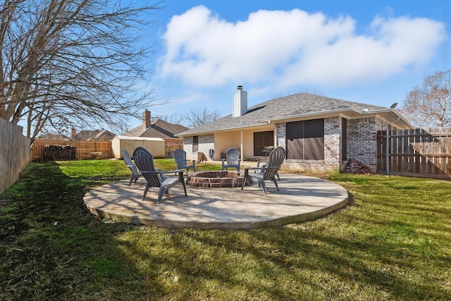 exterior space with a patio area, a fire pit, a storage shed, and a fenced backyard