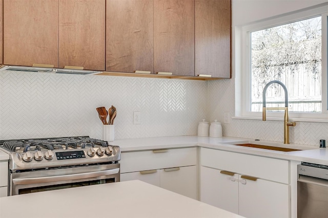 kitchen featuring a sink, white cabinetry, stainless steel appliances, and light countertops