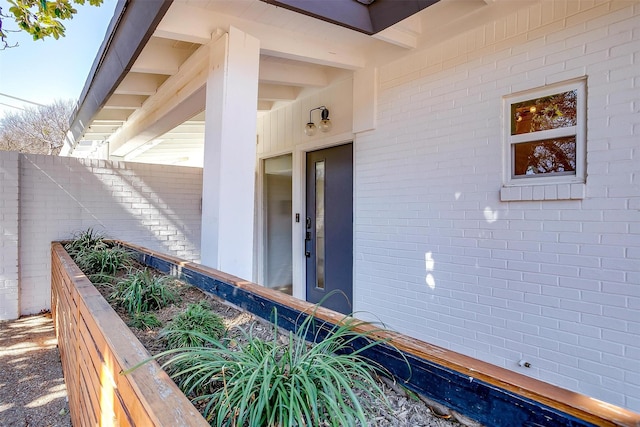 view of exterior entry featuring fence