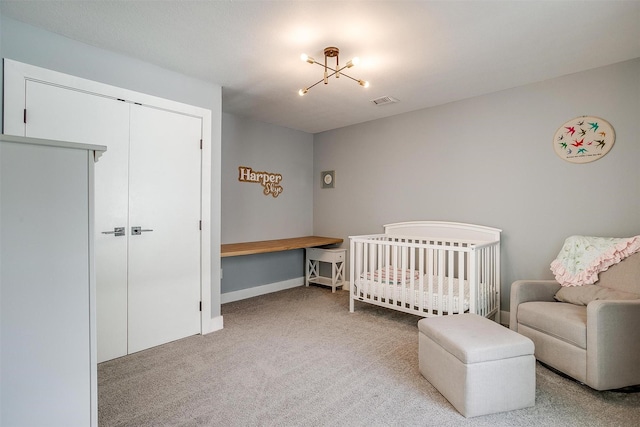 carpeted bedroom with a crib, a closet, visible vents, and baseboards