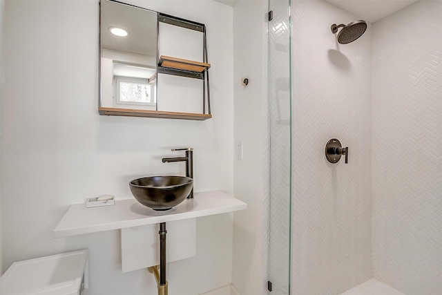 full bath with a sink and tiled shower