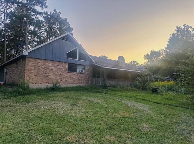 view of home's exterior with a lawn and brick siding