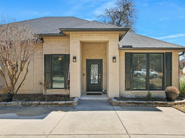 property entrance with brick siding and a shingled roof