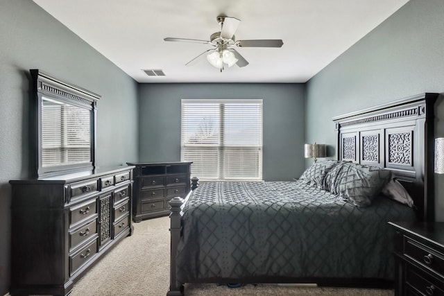 carpeted bedroom featuring visible vents and a ceiling fan