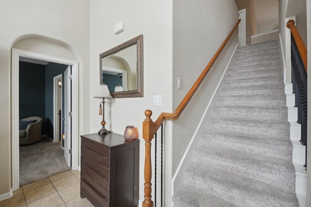 stairs featuring tile patterned flooring and carpet flooring