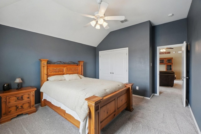 bedroom featuring visible vents, a ceiling fan, a closet, light colored carpet, and vaulted ceiling