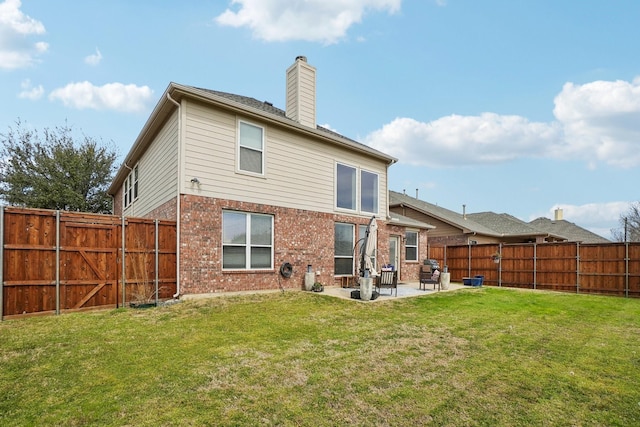 rear view of house featuring a patio area, brick siding, a fenced backyard, and a lawn