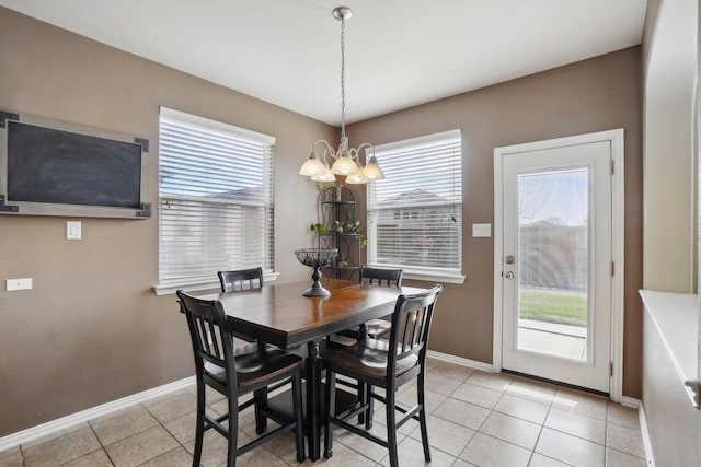 dining area with light tile patterned floors, baseboards, and a chandelier