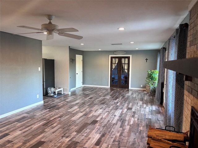 unfurnished living room featuring visible vents, baseboards, wood finished floors, french doors, and a fireplace