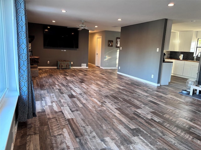 unfurnished living room with ceiling fan, baseboards, dark wood-style flooring, and recessed lighting