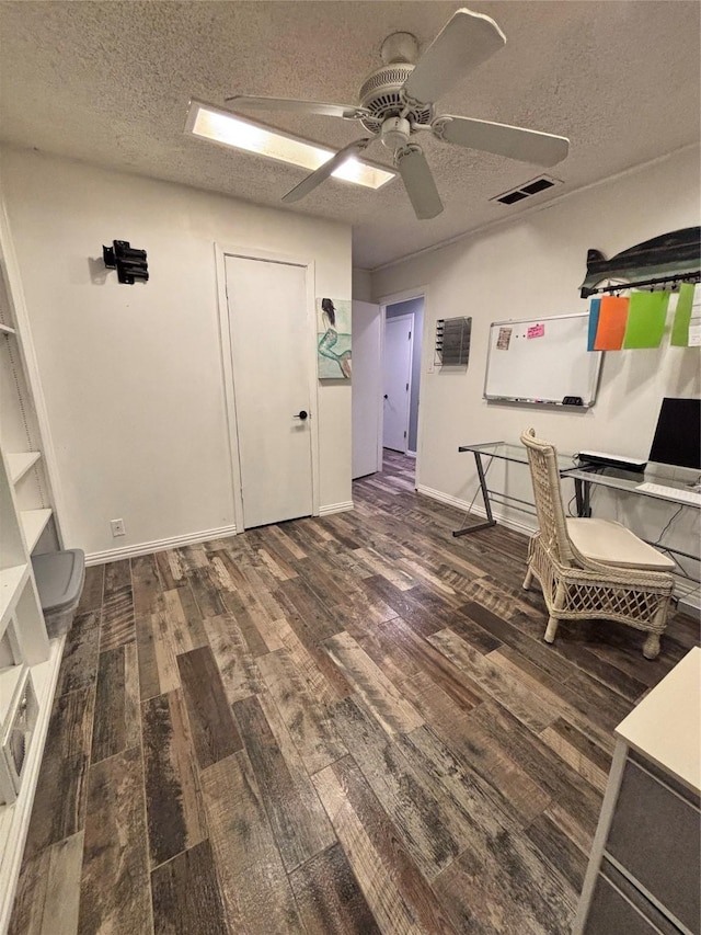 interior space featuring visible vents, ceiling fan, a textured ceiling, wood finished floors, and baseboards