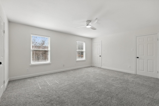 spare room with carpet, baseboards, and a ceiling fan