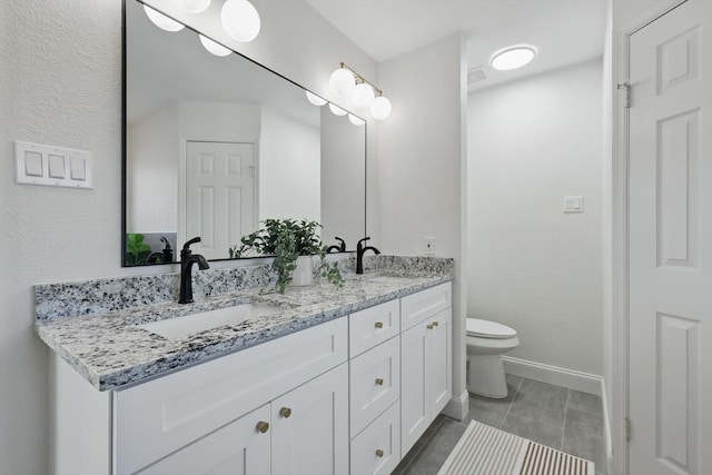 full bathroom featuring double vanity, a sink, toilet, and baseboards