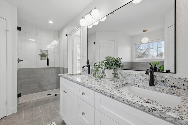 full bathroom featuring tile patterned floors, a sink, a shower stall, and double vanity